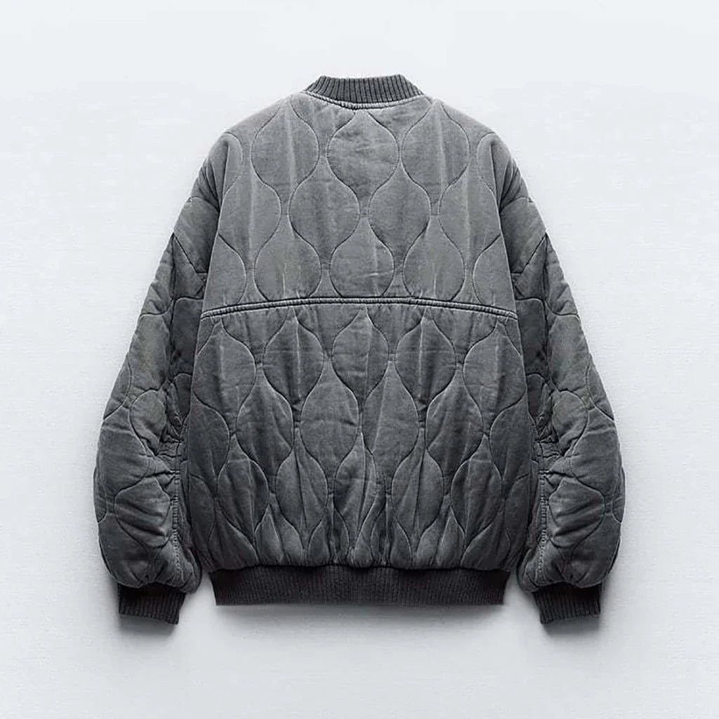 Model in a gray women's quilted bomber jacket. Casual yet stylish layering for autumn fashion outerwear.