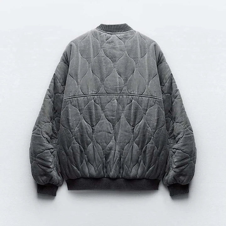Model in a gray women's quilted bomber jacket. Casual yet stylish layering for autumn fashion outerwear.