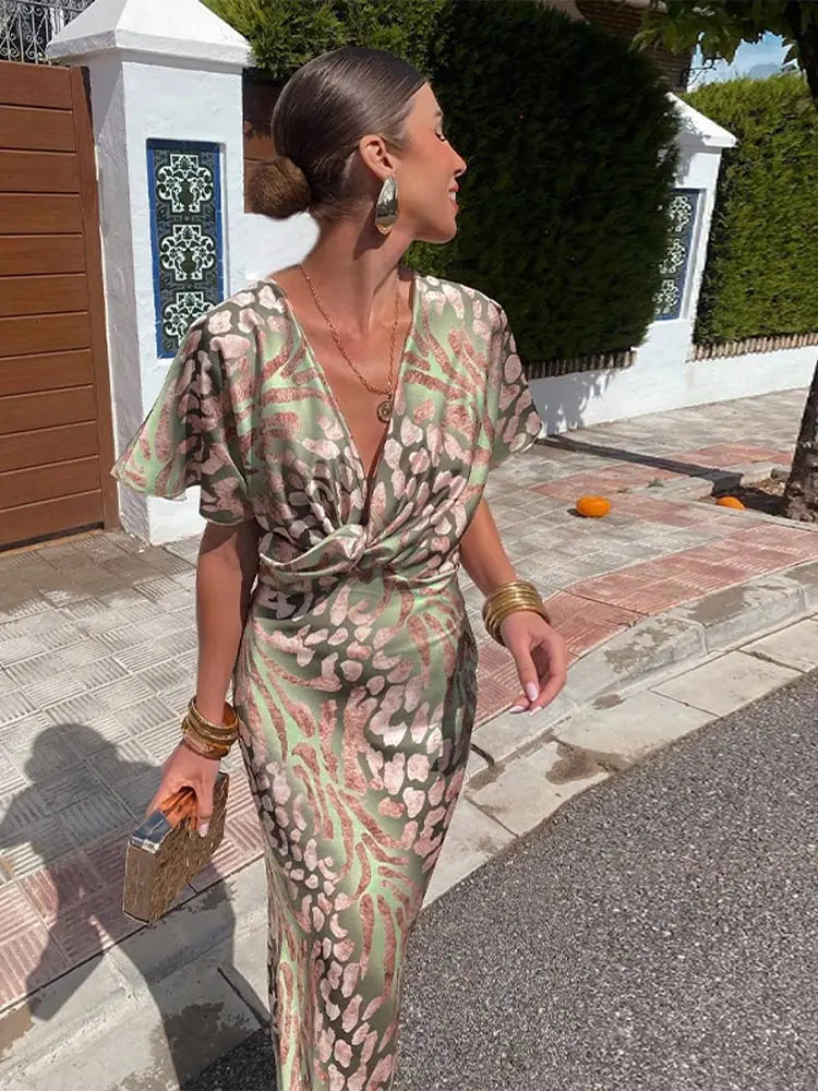Green abstract print wrap midi dress for women. Relaxed fit, short sleeve, elegant summer party or vacation wear.
