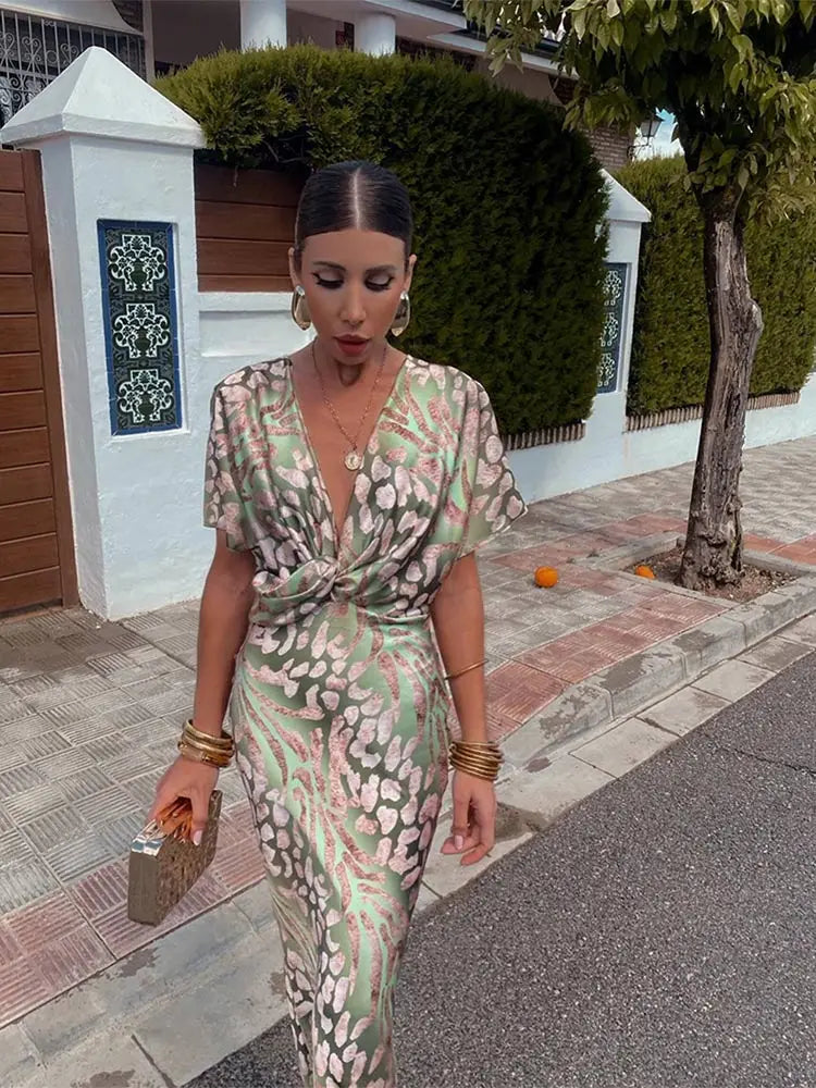Women's relaxed fit midi wrap dress with a vibrant abstract print. Short sleeve, ideal for elegant party or vacation style.