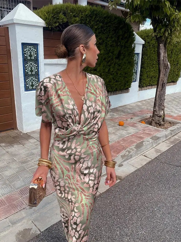 Elegant flowy women's abstract print wrap midi dress in green. Relaxed fit, short sleeve, stylish for summer occasions.