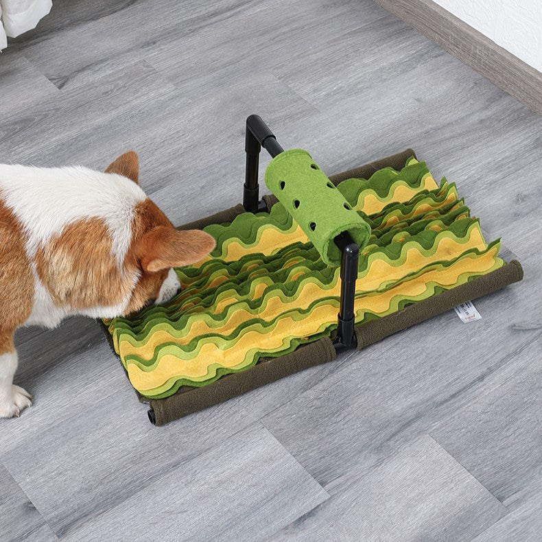 Dog happily sniffing and eating from a green snuffle mat, a slow feeder & puzzle toy