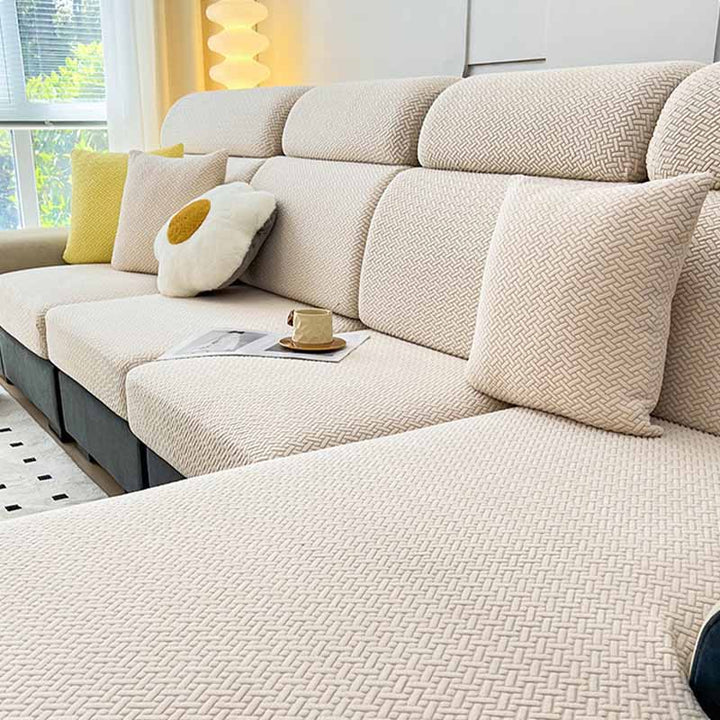 Beige elastic couch cover made of soft fleece, offering furniture protection for all seasons.