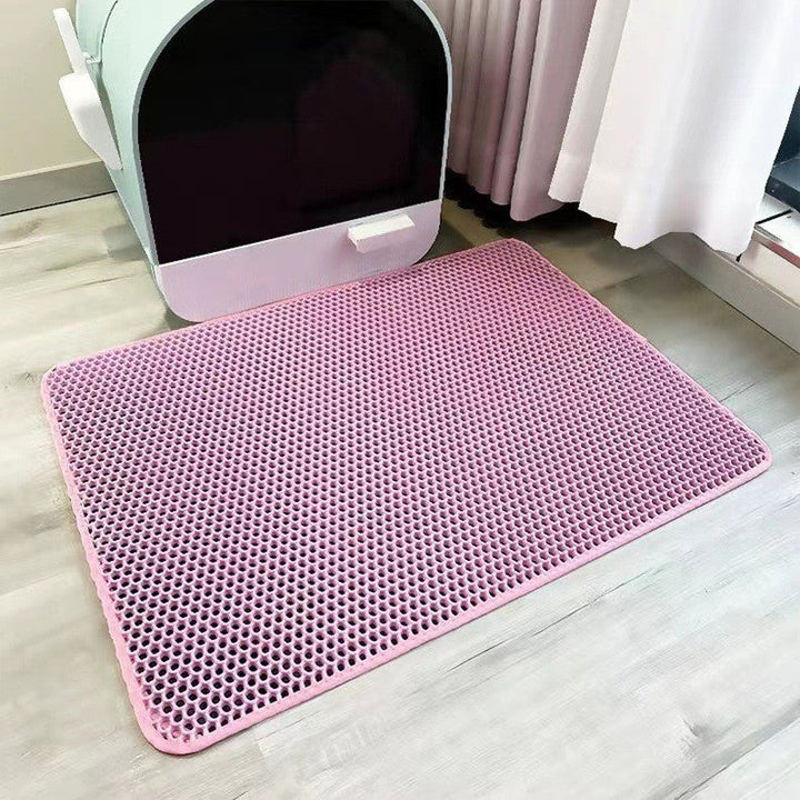 A cat stepping onto a durable, easy-clean litter mat, designed to trap granules and keep floors tidy.