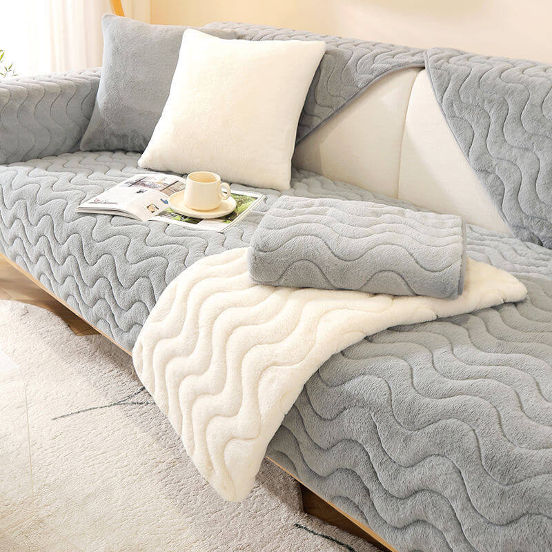 Grey plush sofa cover with wave pattern, non-slip backing, protecting a couch
