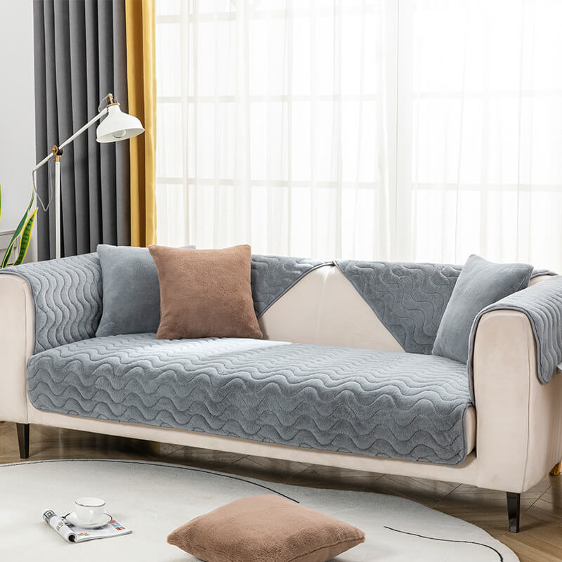 Overhead view of a green plush sectional cover with subtle woven wave pattern