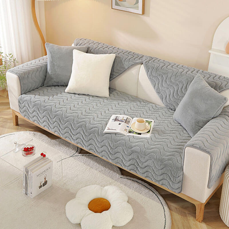 Detail of the soft, plush fabric of the wave pattern sofa cover in grey