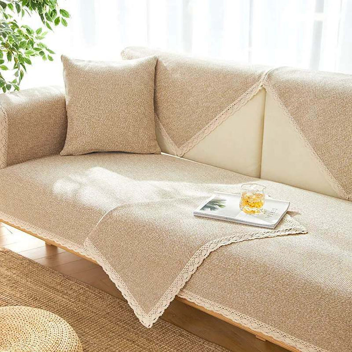 Hand-woven cotton linen non-slip couch cover in a neutral tone, protecting a 3-seater sofa