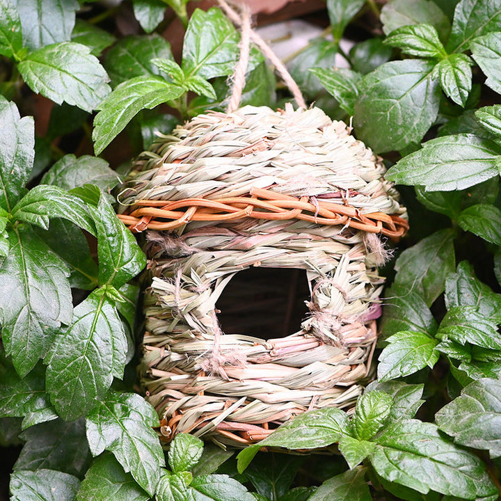 Rustic decorative bird house made from green hand-woven straw, ideal for small garden birds