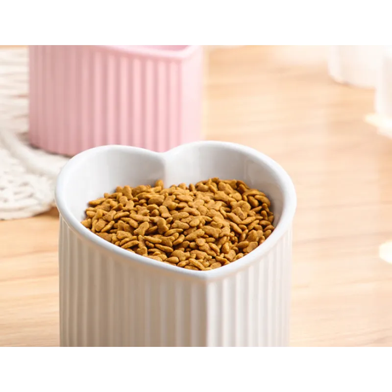 Set of two heart-shaped ceramic pet bowls, red and white, non-slip feeders for food and water.