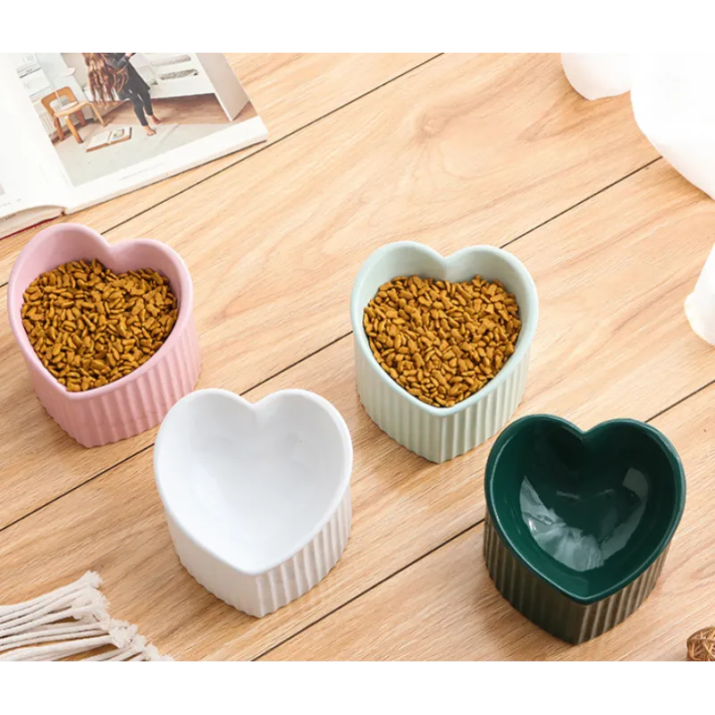 Heart-shaped ceramic pet bowl on a wooden floor, showcasing its non-slip design and hygiene.
