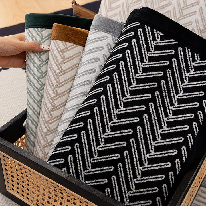 Stylish herringbone sofa cover in blue with fringed edge, non-slip base for secure furniture protection.