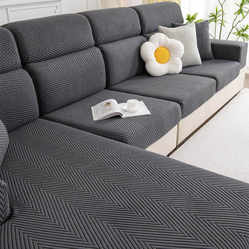 Child and dog playing on a sofa protected by a durable herringbone chenille stretch cover