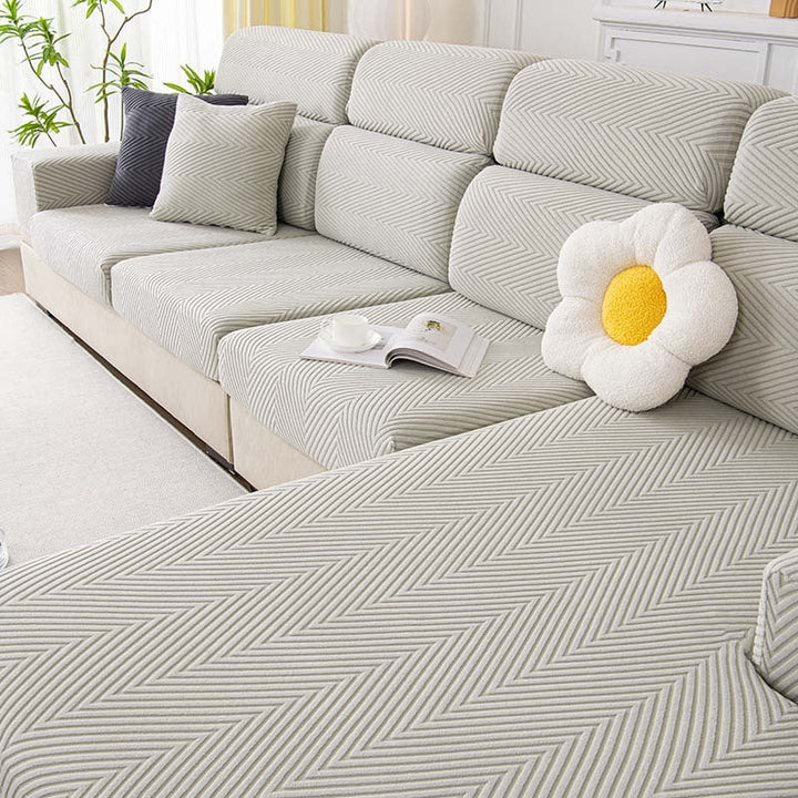 Close-up of herringbone texture on a gray stretch chenille couch cover, pet-friendly design