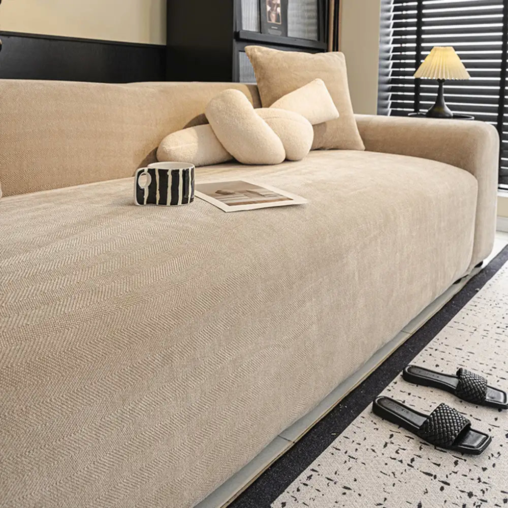 Stylish herringbone patterned slipcover extending full coverage over a sofa, ideal for pet owners and easy care.