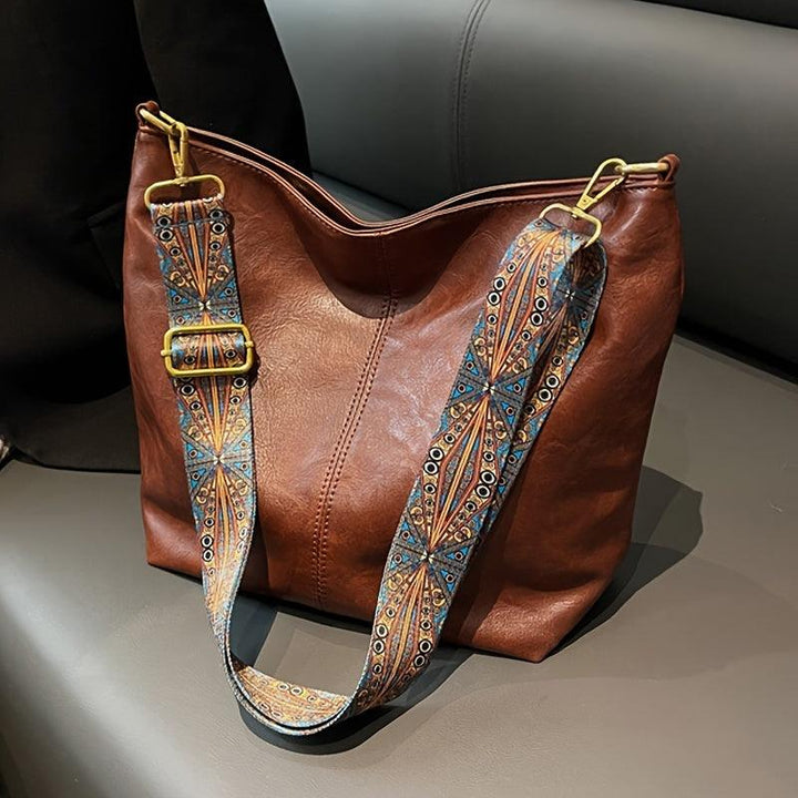 Women's bohemian shoulder bag with a striking patterned guitar strap. Perfect fashion accessory.