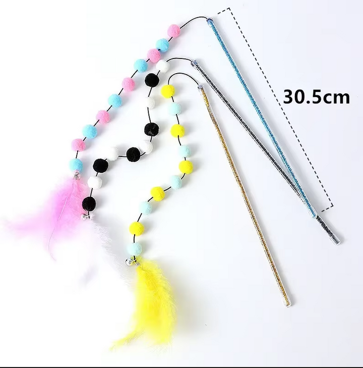 Close-up of a feather and pom-pom attachment on a flexible cat fishing rod toy, stimulating feline play