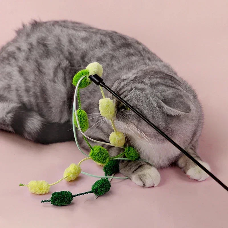 Close-up of a cat fishing rod teaser wand featuring a jingling bell and vibrant tassel for interactive play