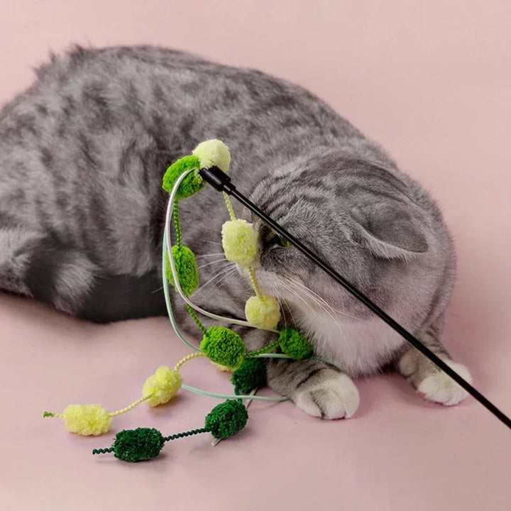 Close-up of a cat fishing rod teaser wand featuring a jingling bell and vibrant tassel for interactive play