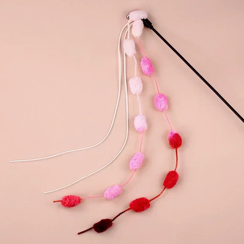 Ergonomic handle of a cat teaser wand with a long, flexible rod, bell, and tassel for engaging playtime