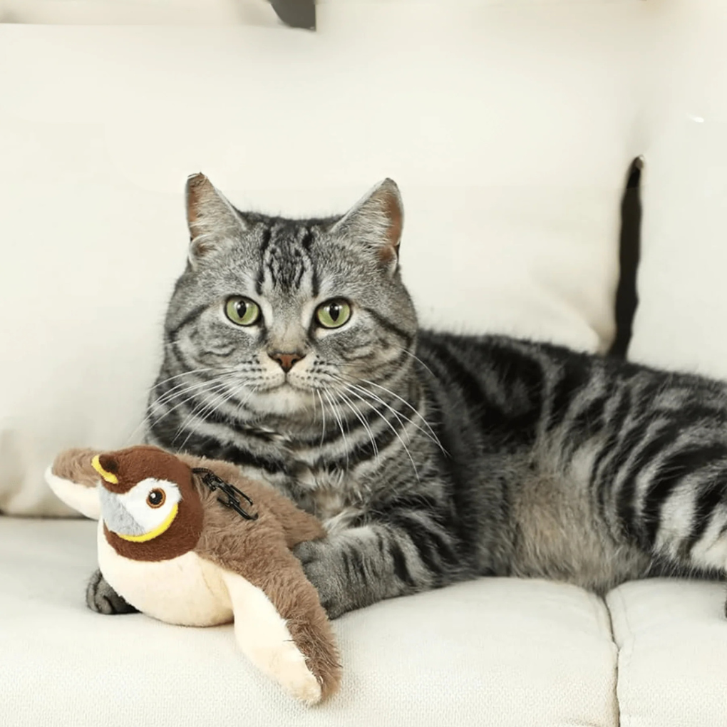 Interactive cat wagging feather toy with a playful kitten batting at its base