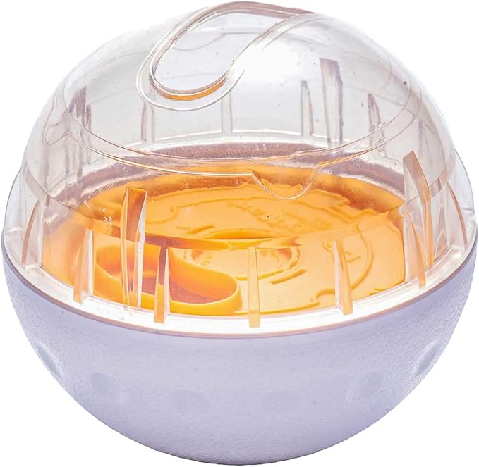 Close-up of a dog playing with an interactive food dispenser ball, a fun pet feeder toy