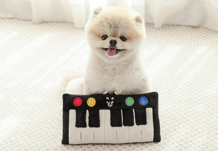 Happy dog playing with Interactive Pet Piano Treat Toy, an engaging pet puzzle feeder
