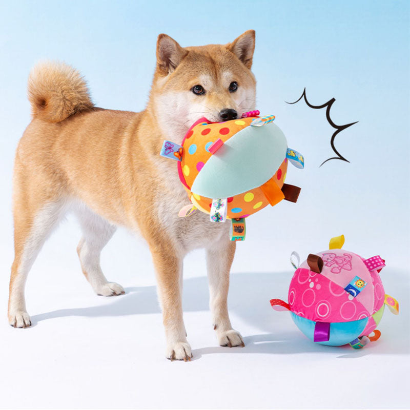 Close-up of a squeaky ball dog toy, plush fabric featuring a stitched animal face, great for puppies.