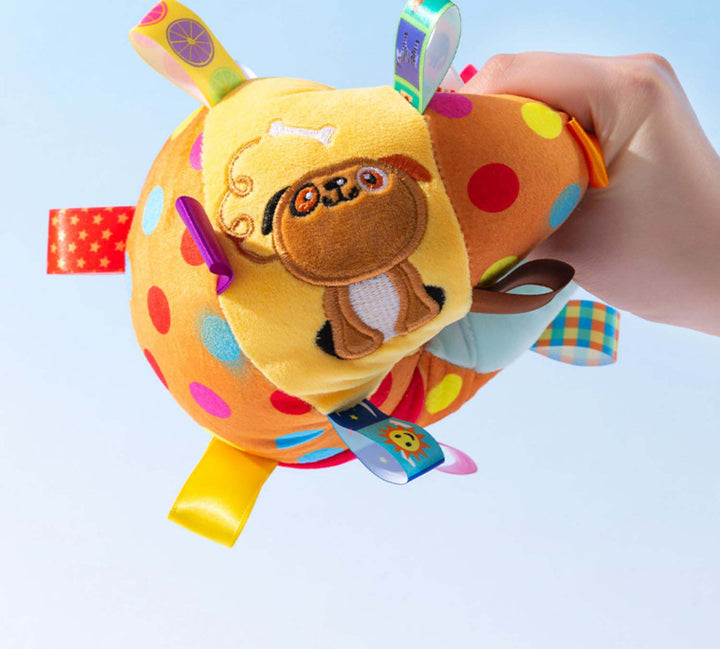 Hand holding an interactive pet squeaky ball toy, highlighting its size and unique animal embroidery.