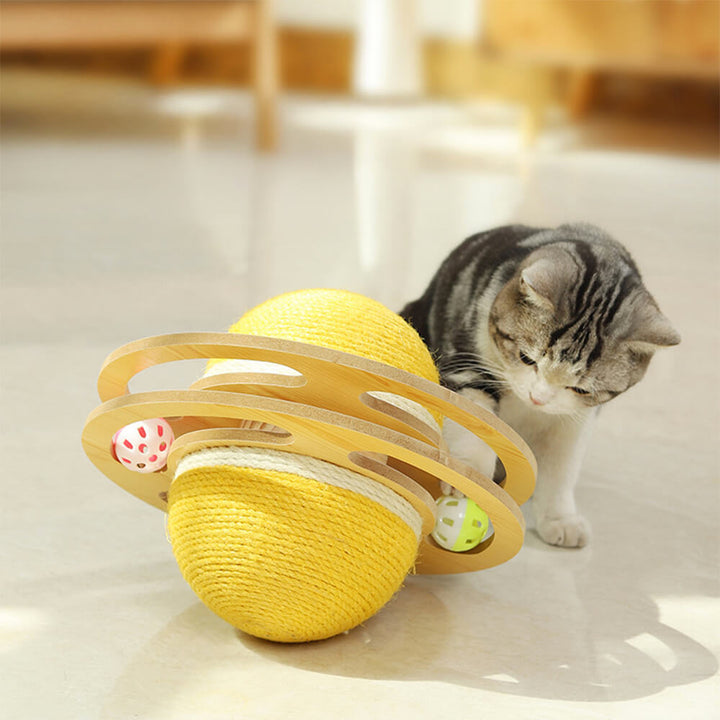 Close-up of a cat pawing at an interactive sisal scratching ball cat toy on a wooden stand