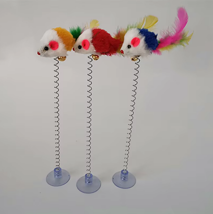 Cat enthusiastically batting at an interactive spring mouse toy attached by a suction cup.