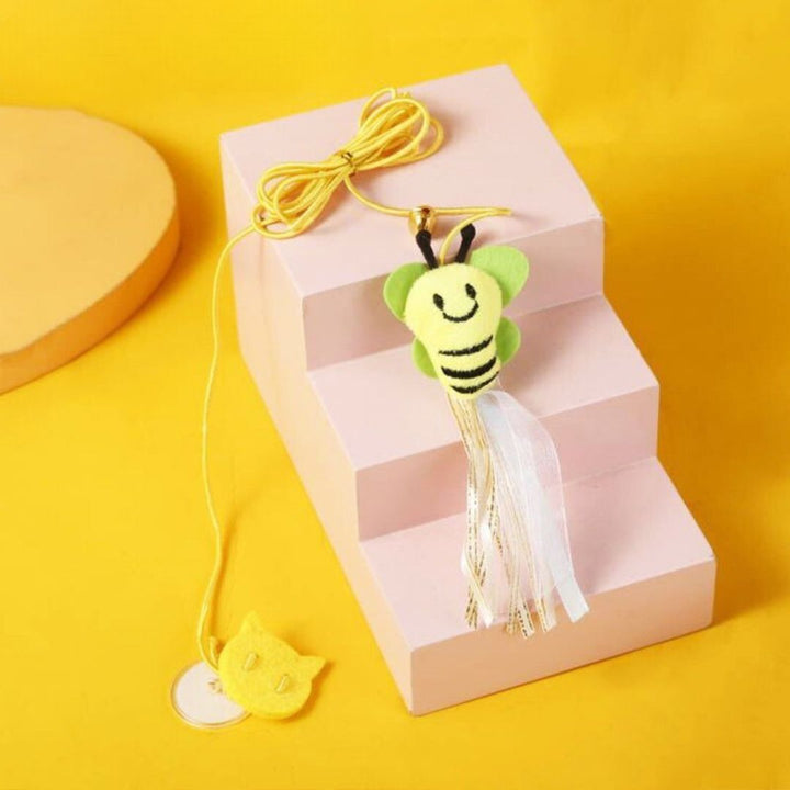 A cat jumping to bat at a suspended bell toy, an engaging pet accessory.