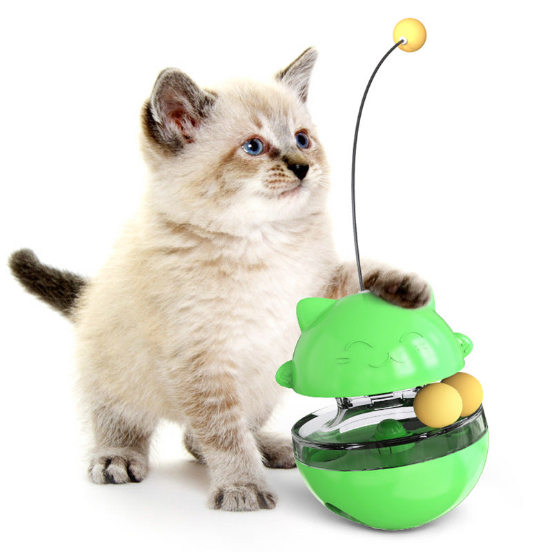 Close-up of a cat pawing at a treat dispensing wobble toy, an engaging pet activity.