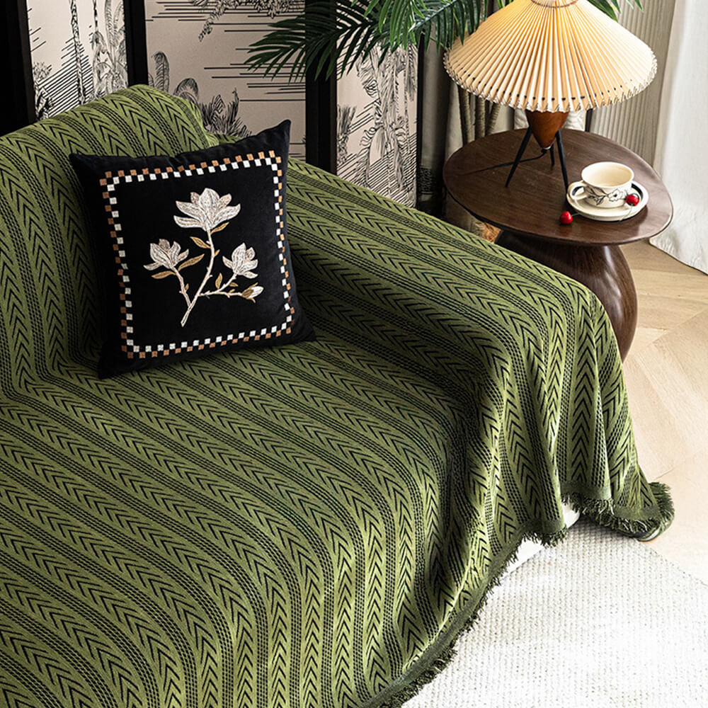 Close-up of jacquard pattern on chenille couch cover with decorative tassel, furniture protection