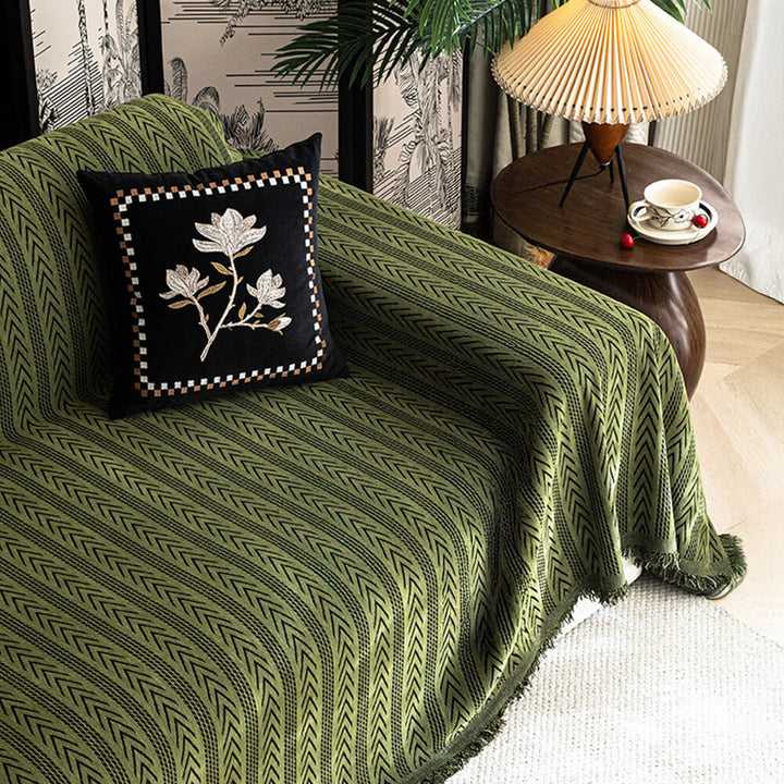 Close-up of jacquard pattern on chenille couch cover with decorative tassel, furniture protection