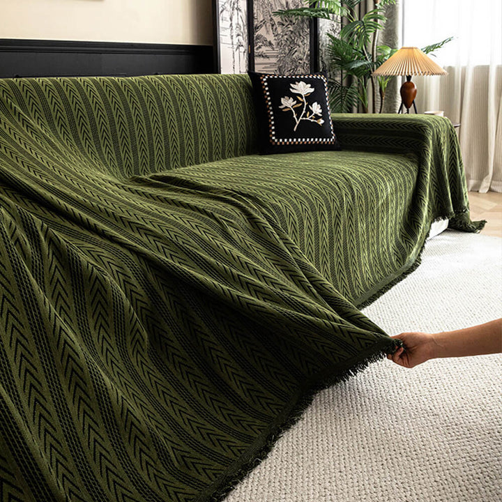 Full view of a couch draped with a jacquard tassel chenille sofa protector, stylish and functional