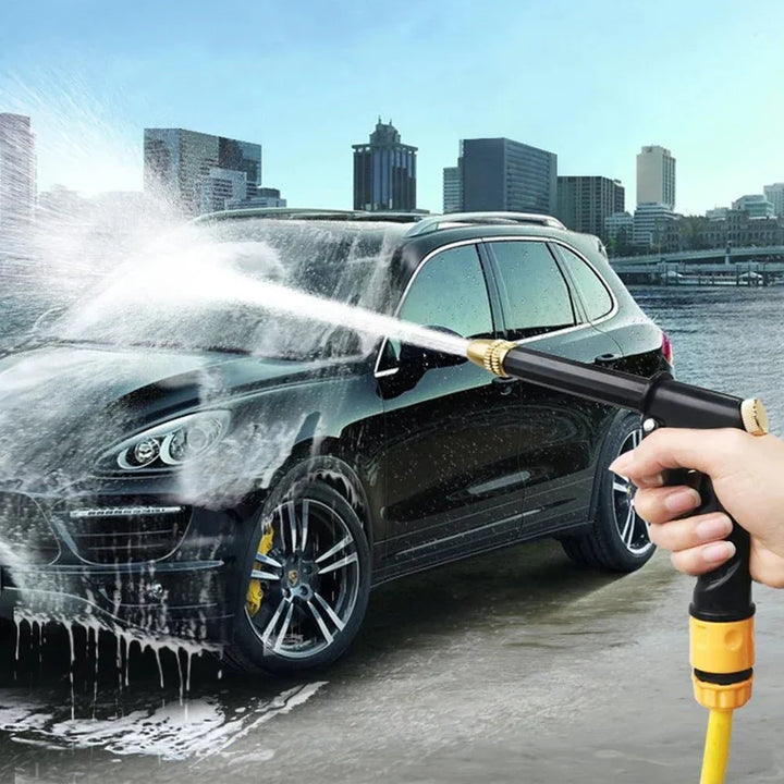 High-pressure water gun effectively cleaning a car, removing dirt with a powerful adjustable spray.