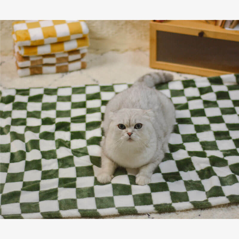 Chequered flannel pet blanket draped over a sofa, showing soft texture and home decor style