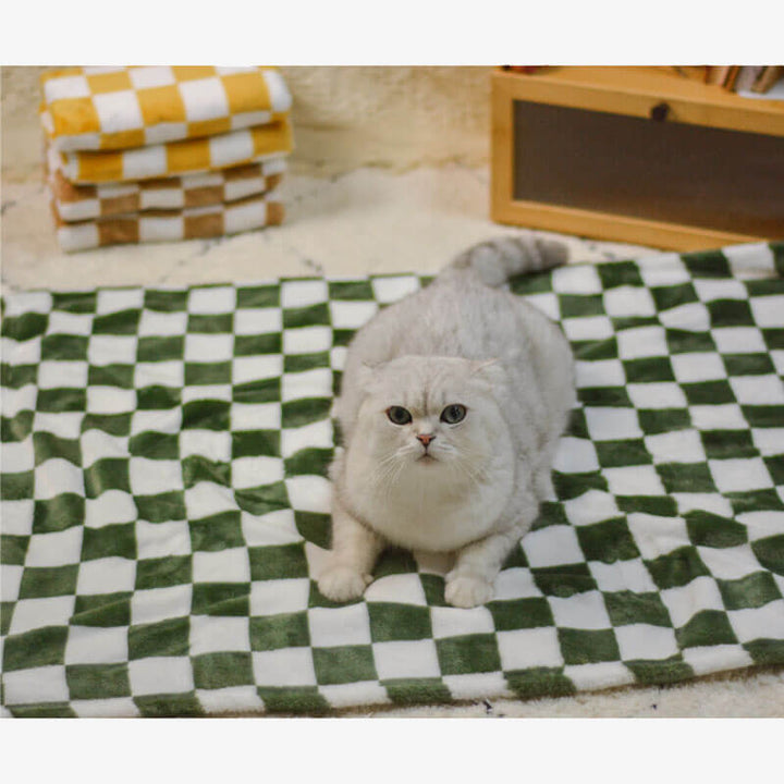 Chequered flannel pet blanket draped over a sofa, showing soft texture and home decor style