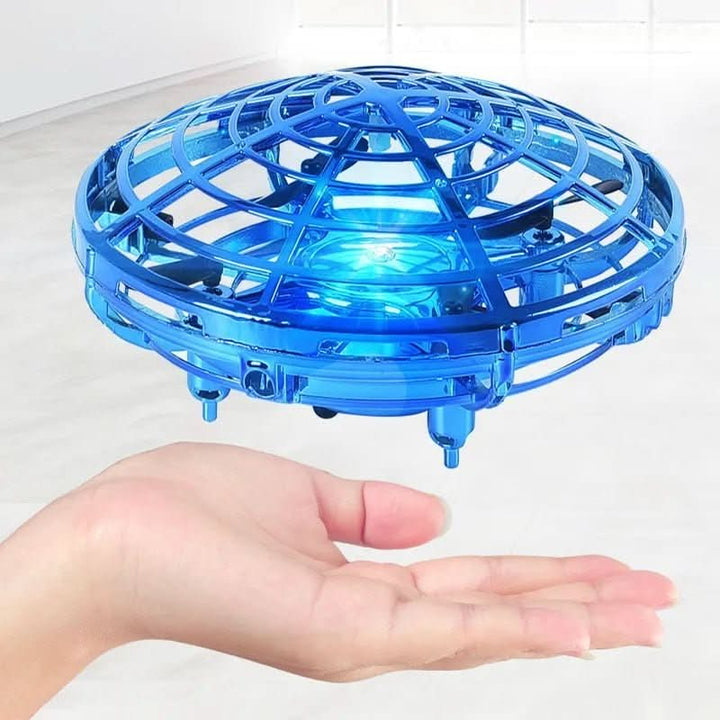 Child's hand guiding a vibrant UFO drone, demonstrating responsive gesture control for interactive play.
