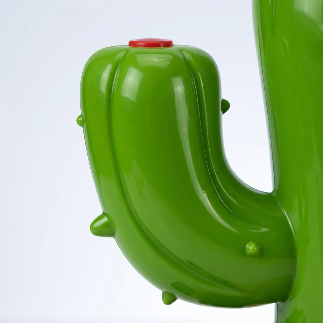 Green cactus sprinkler with rotating arms spraying water, perfect for kids' outdoor summer backyard fun.