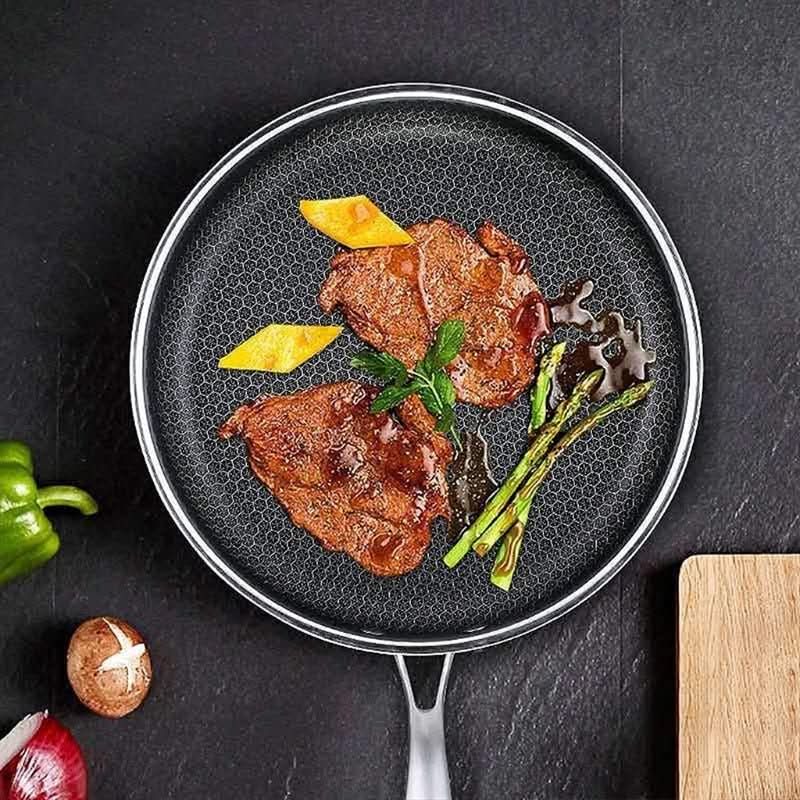 Non-stick stainless steel frying pan cooking a perfectly fried egg. Essential durable kitchenware.