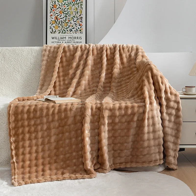 Person snuggled under a plush, warm fleece blanket, enjoying ultimate cozy comfort at home.