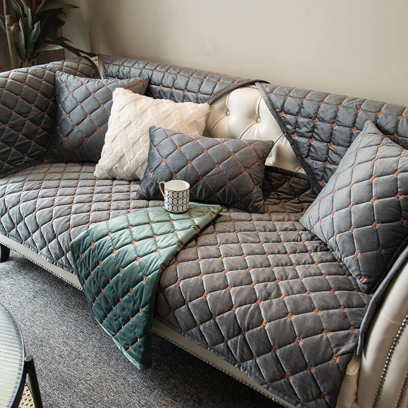 Luxury velvet quilted non-slip sofa cover in elegant grey, protecting furniture & enhancing home decor.