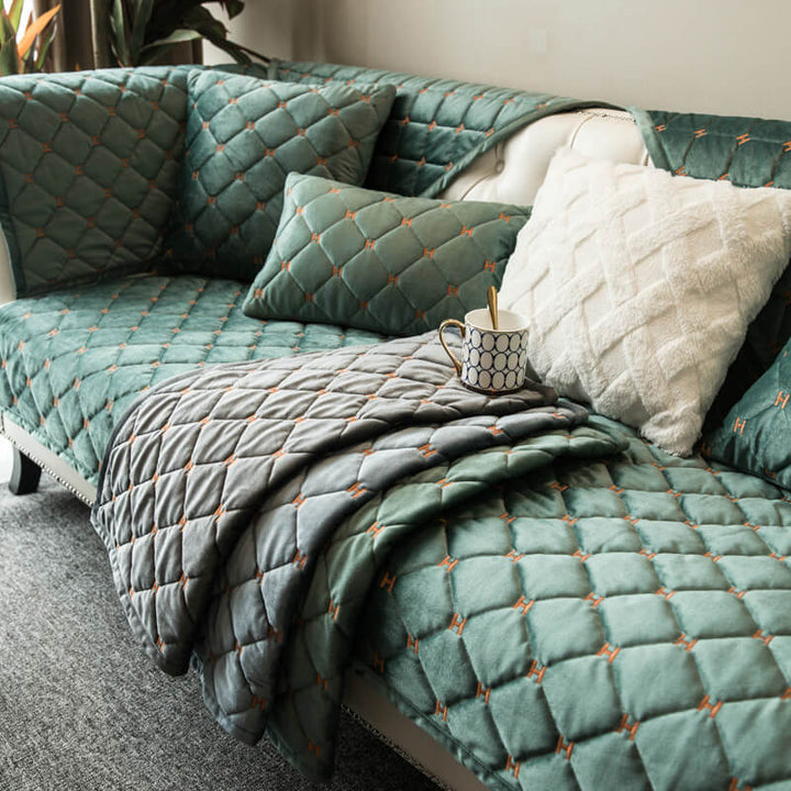 Soft velvet quilted couch cover with non-slip backing, designed for luxury furniture protection.