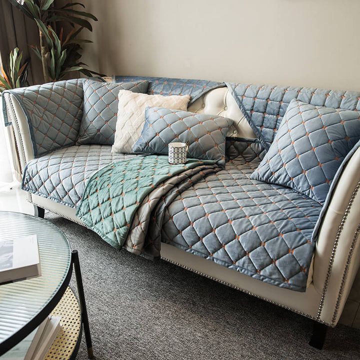 Close-up of quilted velvet sofa protector, showing intricate stitching and plush texture for home decor.