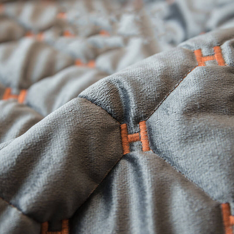 Elegant velvet quilted couch cover draped over a sofa, displaying its non-slip design and modern feel.