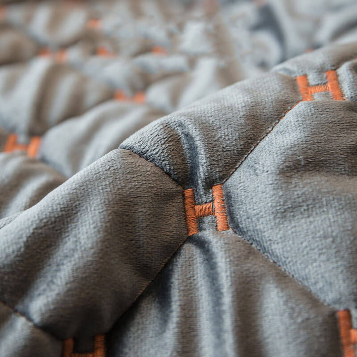 Elegant velvet quilted couch cover draped over a sofa, displaying its non-slip design and modern feel.