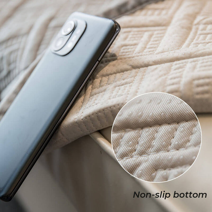Detailed view of the non-slip backing on a quilted velvet couch protector, ensuring furniture stability.