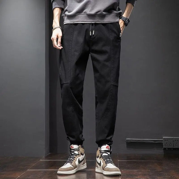 Detail of men's tapered joggers: soft fabric, ribbed cuffs, and drawstring for ultimate comfort pants.